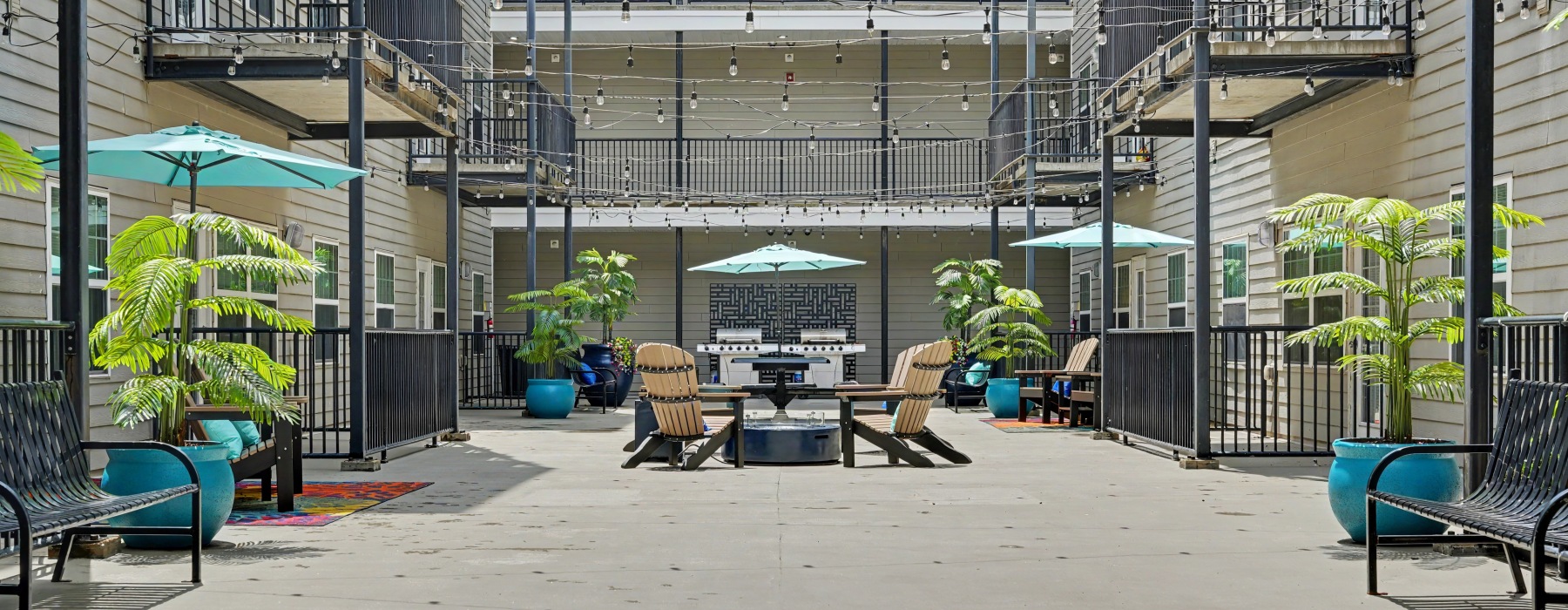 Large open courtyard with seating, firepit, games, and grills
