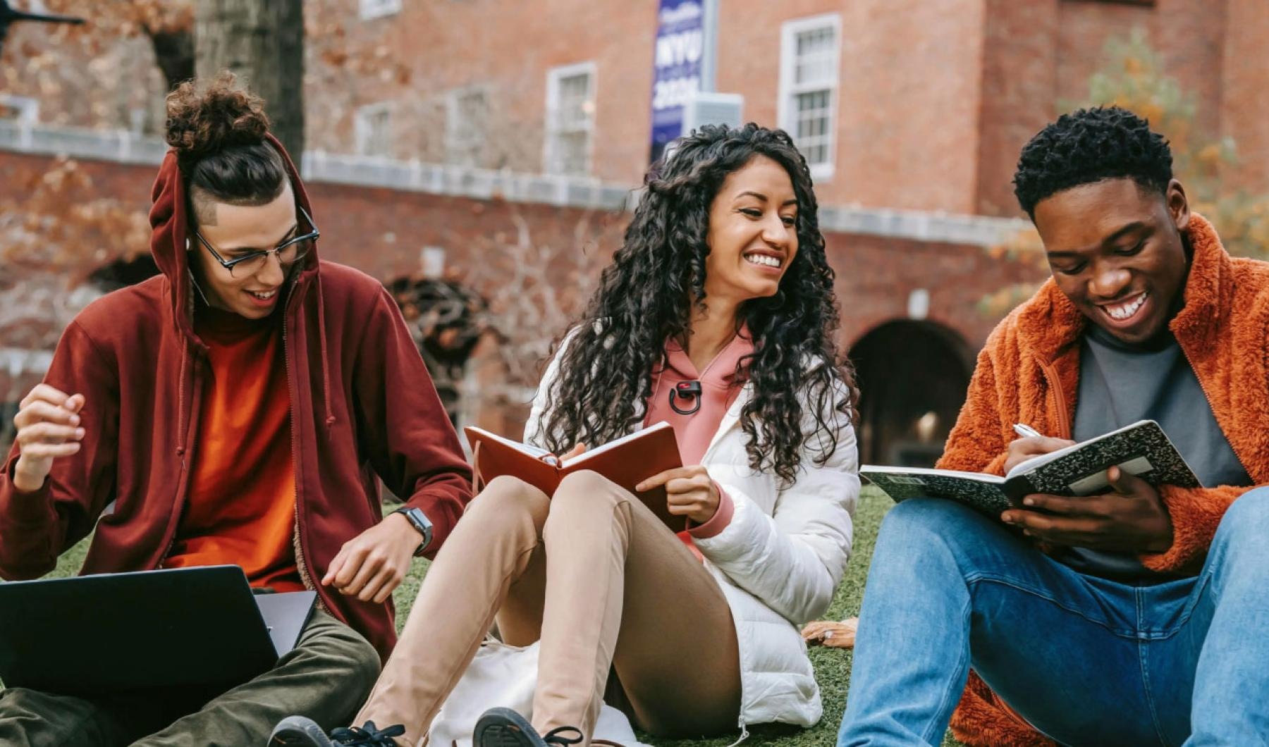 a group of people sitting on a bench with a laptop