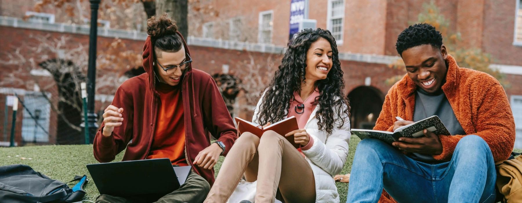 a group of people sitting on a bench with a laptop