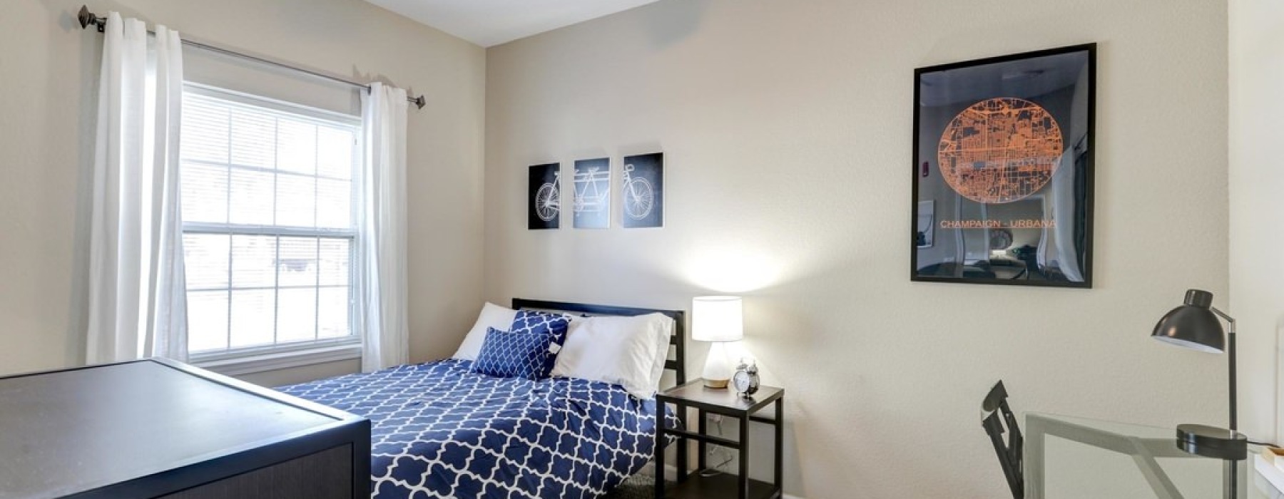 bedroom with a desk, dresser, and nightstand